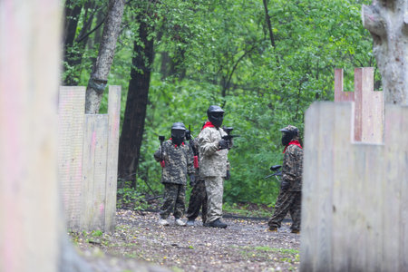 Warriors in camouflage and masks playing paintballの写真素材