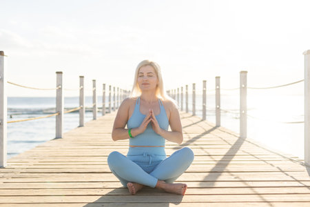woman exercising on pontoon by the seaの写真素材