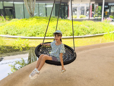 The girl sits on a swing attached to the treeの写真素材