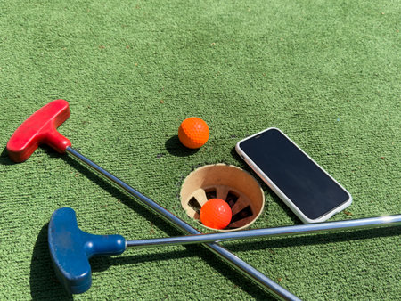 Series with golf clubs, smartphone and balls on artificial grass.の写真素材