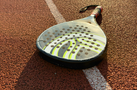 professional paddle tennis racket with natural lighting on court background. Horizontal sport theme...