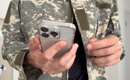 Side view of army soldier text messaging against white backgroundの写真素材