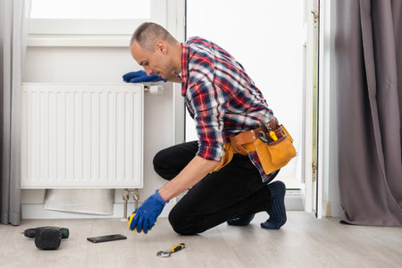 plumber at work. Installing water heating radiatorの写真素材