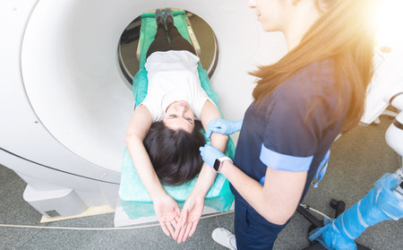 beautiful woman lying on ct scanner bed during tomography test in hospitalの写真素材