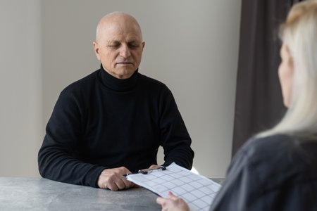 Young woman helping elderly man to read questionnaireの写真素材