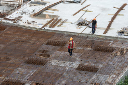 Construction workers install formwork and iron rebars or reinforcing bar for reinforced concrete...