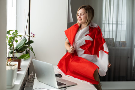 Young female student with Canadian flag and laptop with space for textの写真素材