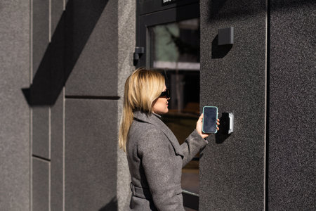 Woman hands using phone scan to digital door lock security systems at home.の写真素材