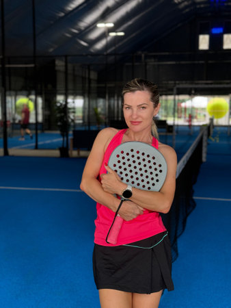 Portrait of beautiful woman playing padel tennis court indoorの写真素材