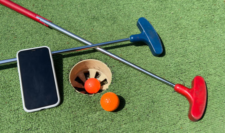 Series with golf clubs, smartphone and balls on artificial grass.の写真素材