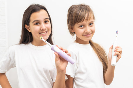 Funny portrait of a young girls brushing