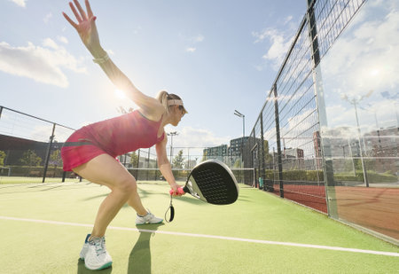 European young woman tennis player in padel tennis playing during a friendly doubles match on the outdoor courtの写真素材