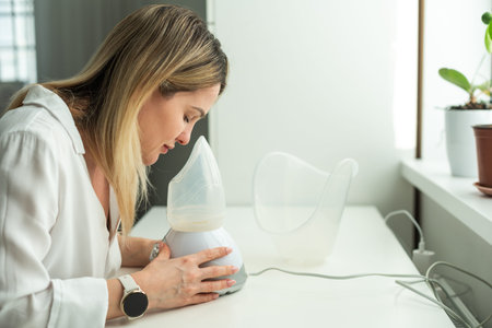 Beautician holding ultrasound device for face and skin lifting procedure and hair removal. Young woman cosmetologist using modern cosmetology equipment in clinic.の写真素材