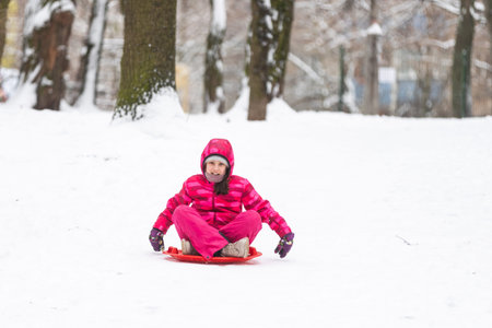 Girl enjoying a sleigh ride, play outdoors in snow.