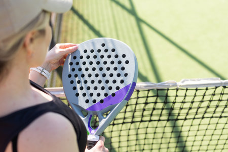 Woman padel tennis player training on court. Woman using racket to hit ball.の写真素材