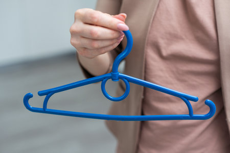 hand holding an empty cloth hangerの写真素材