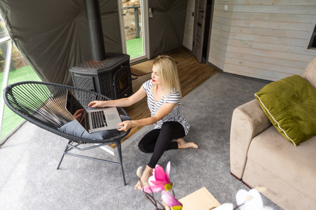 Image of young pleased happy cheerful cute business woman using laptop computer listeningの写真素材