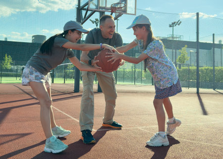Basketball trainer showing how to shoot basketball to a child . Coach training a kid.の写真素材