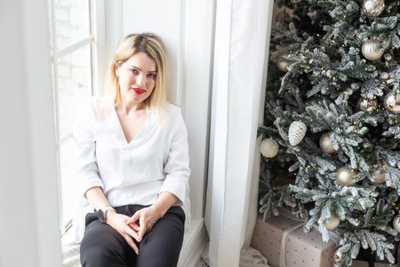 happy woman against Christmas tree background.の写真素材