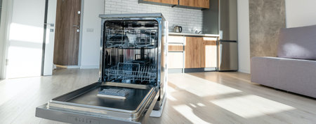 An empty dishwasher, opened, in the modern kitchen of a home.の写真素材