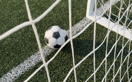 Soccer ball in goal on blue backgroundの写真素材