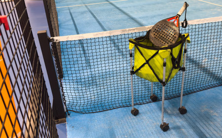 Padel balls on court in basket