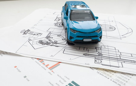 Small toy car close up image on blueprint background.