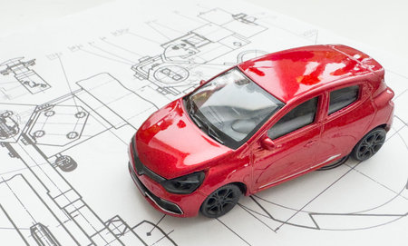 Small toy car close up image on blueprint background.