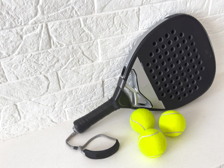 Set of paddle tennis rackets and balls on white table and white isolated background. Front view.の写真素材