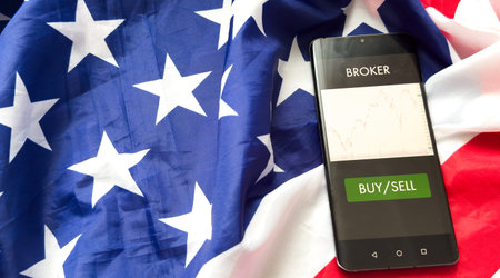 Investors analyze the data stock market index via smartphone screen to trade the stock chart for...
