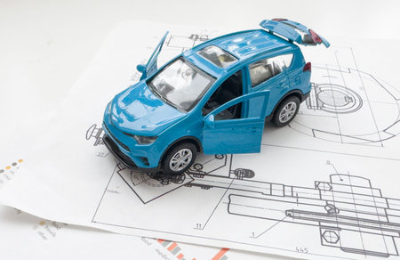 Small toy car close up image on blueprint background.