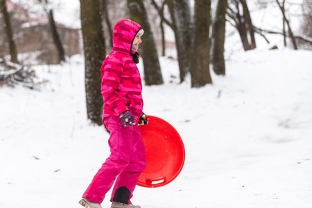 Girl enjoying a sleigh ride outdoors in snow.
