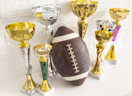Sports, award and trophy for success, winner or achievement. Prize, victory and sport reward on a ground at an empty stadium for sport, champion and competition.の写真素材