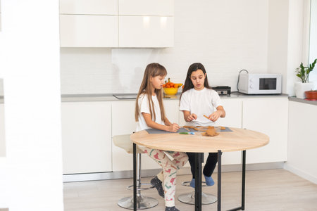 Two girls, sisters, are preparing Christmas cookies in the kitchen and playing around . Christmas, New Year conceptの写真素材