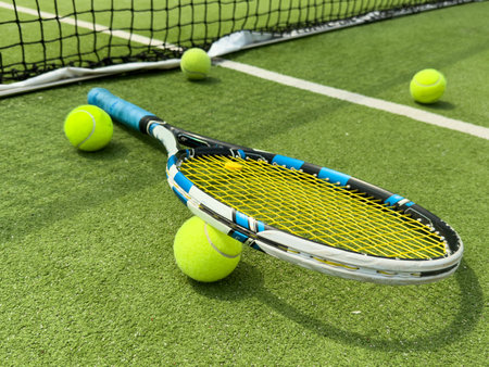 Tennis racket and ball on a tennis courtの写真素材