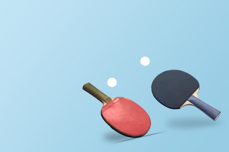 Red ping pong table tennis paddle rackets with ball on blue background. Summer sport activity concept.の写真素材