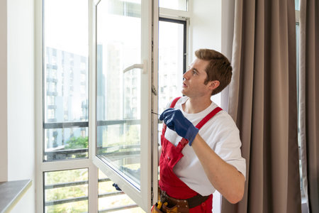 Construction worker installing window in house
