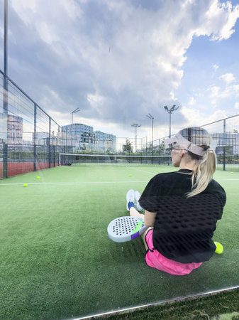 Sporty european woman padel tennis player trains on the outdoor courtの写真素材
