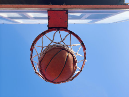 Bottom view of red basketball hoop with ball flying in. Copy spaceの写真素材