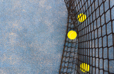 Net of a blue paddle tennis court and balls. Racket sports concept.の写真素材