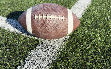 American Football on the Field Close Up with Yard Lines Beyond
