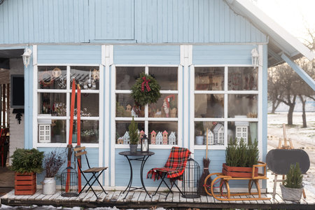 Table for two. Christmas bakery exterior with Christmas decorations. Cozy outdoor cafe on Christmas eve. Copy space. seasonal greetings concepts.の写真素材