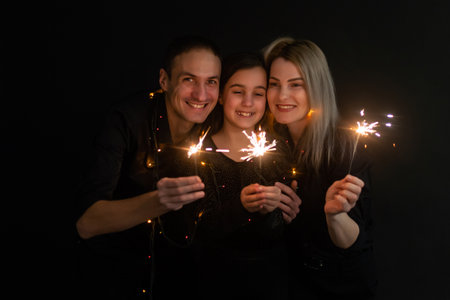 Beautiful family celebrating and holding sparklersの写真素材