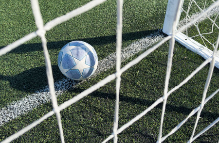 soccer ball flies into the gate on a green background. Close up.の写真素材