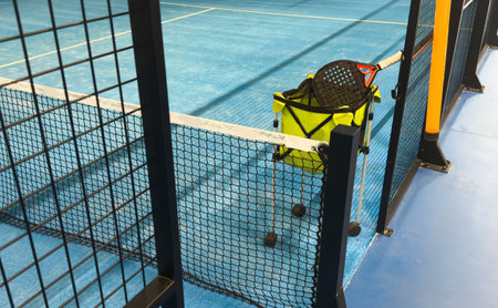 Paddle tennis racket, basket and balls in court imageの写真素材