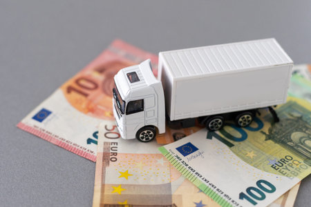 White toy truck lie on dollars, space for text.の写真素材