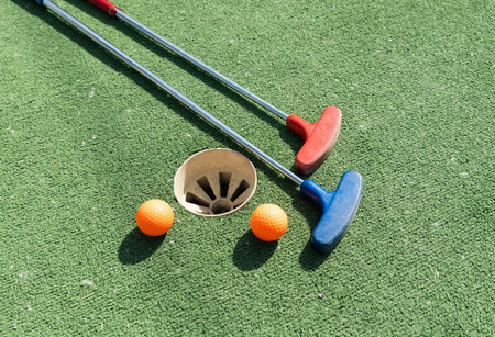 Golf stick and ball on green turf close up.の写真素材