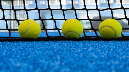 paddle tennis balls near the lines of a blue paddle tennis court, racket sports conceptの写真素材