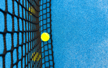 balls near the net of a blue paddle tennis court, sports courtsの写真素材