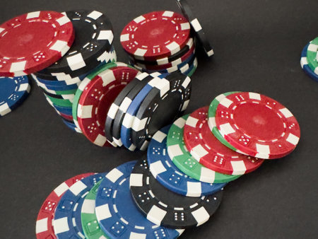 Colorful different value poker chips on black casino table, win after game. Concept of hazard gamingの写真素材